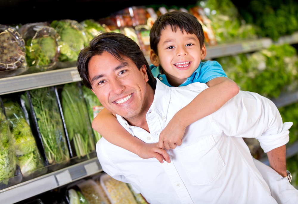 Fun dad carrying children at the supermarket