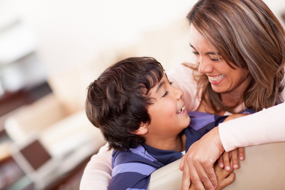 Happy mother with her son smiling at home