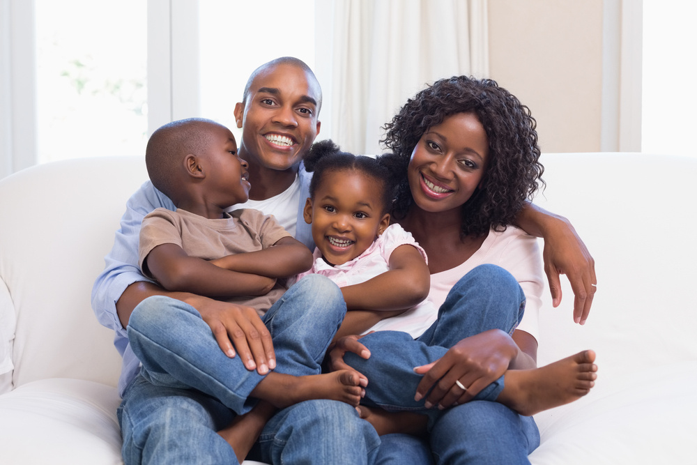 Happy family posing on the couch together at home in the living room-1